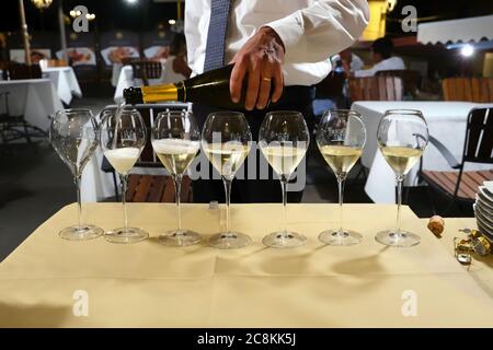 Un sommelier versa un prosecco nei bicchieri di un ristorante Foto Stock