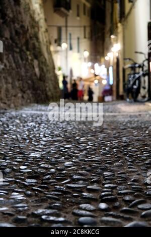 Vista ravvicinata di una strada acciottolata ad Alghero, Italia Foto Stock