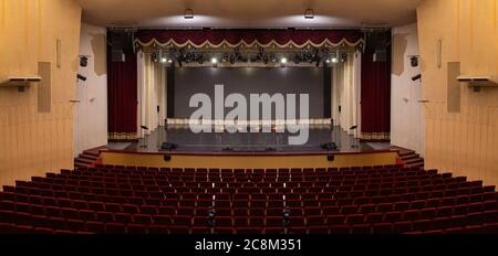 Un palcoscenico vuoto del teatro, illuminato da faretti e fumo prima dello spettacolo Foto Stock