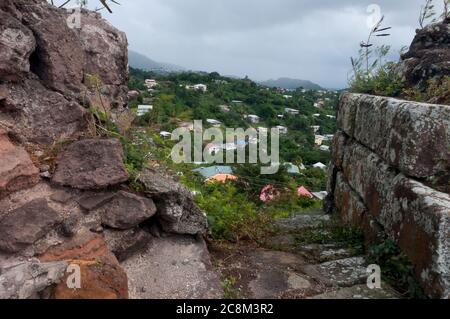 Vista tra le mura di pietra di Fort Frederick, un antico forte dei Caraibi, alle montagne sottostanti. Foto Stock