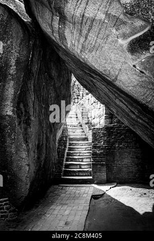 Una scalinata sotto due rocce che lascia la fortezza di Sigiriya Rock nello Sri Lanka Foto Stock