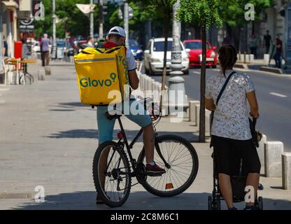 Bucarest, Romania - 30 giugno 2020: Un corriere di consegna di cibo di Glovo consegna consegna il cibo a Bucarest, Romania. Foto Stock