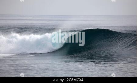 Un'onda si rompe senza guida su una barriera corallina poco profonda nelle Isole Mentawai - Indonesia Foto Stock