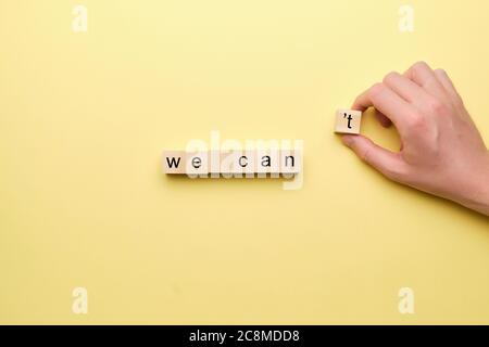 Possiamo come concetto motivante sui blocchi di legno con una mano Foto Stock