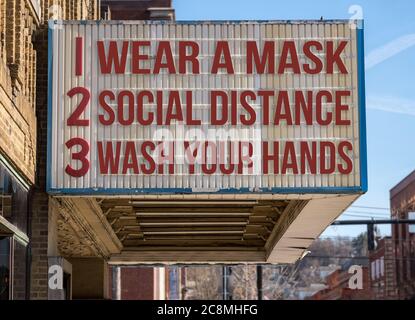 Mockup di film cinema cartellone con indossare una maschera, distanza sociale e lavarsi le mani per affrontare l'epidemia di coronavirus. Foto Stock