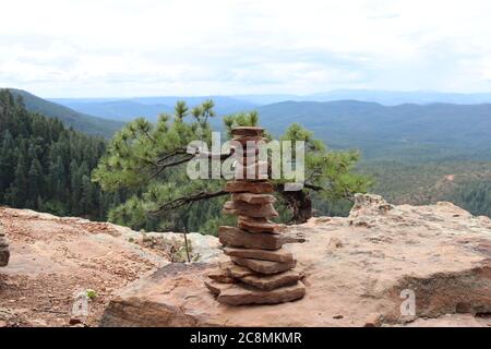 Rocce bilanciate, conosciute anche come Cairns di fronte ad un pino Ponderosa, lungo il Mogollon Rim, nell'Arizona del Nord. Foto Stock