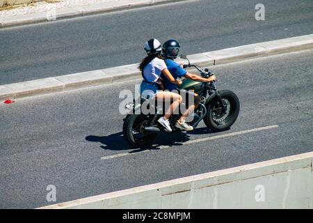 Lisbona Portogallo 25 luglio 2020 Vista di persone non identificate che guidano una motocicletta nelle strade di Lisbona, la città costiera collinare capitale del Portogallo An Foto Stock