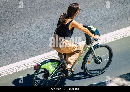 Lisbona Portogallo 25 luglio 2020 Vista di una donna non identificata che rotola con una bicicletta nelle strade di Lisbona, la città costiera collinare capitale del Portogallo A. Foto Stock