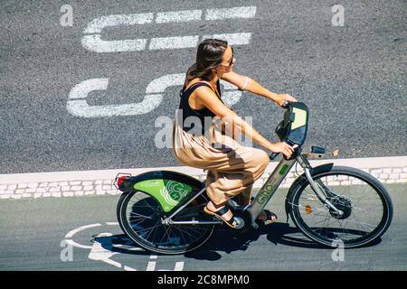 Lisbona Portogallo 25 luglio 2020 Vista di una donna non identificata che rotola con una bicicletta nelle strade di Lisbona, la città costiera collinare capitale del Portogallo A. Foto Stock