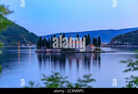 Vista panoramica dell'isola di San Giorgio con un monastero secolare e alti cipressi nella famosa baia di Kotor vicino a Perast, Montenegro al tramonto Foto Stock