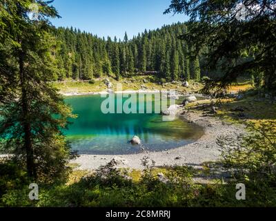 Il Karersee sotto il Passo del Karerai piedi del massiccio del Latemar in Alto Adige, Italia Foto Stock