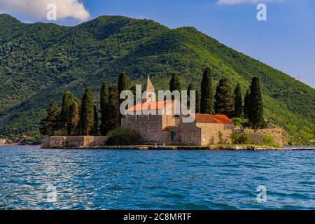 Vista panoramica dell'isola di San Giorgio con un monastero secolare e alti cipressi nella famosa baia di Kotor vicino a Perast, Montenegro al tramonto Foto Stock