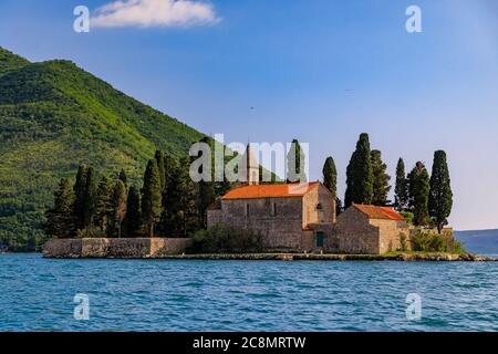 Vista panoramica dell'isola di San Giorgio con un monastero secolare e alti cipressi nella famosa baia di Kotor vicino a Perast, Montenegro al tramonto Foto Stock