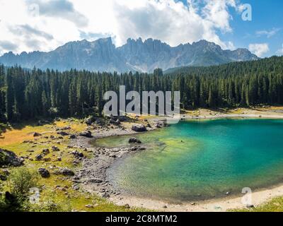 Il Karersee sotto il Passo del Karerai piedi del massiccio del Latemar in Alto Adige, Italia Foto Stock