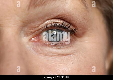 Occhio blu della donna anziana guardare dritto. Foto Stock