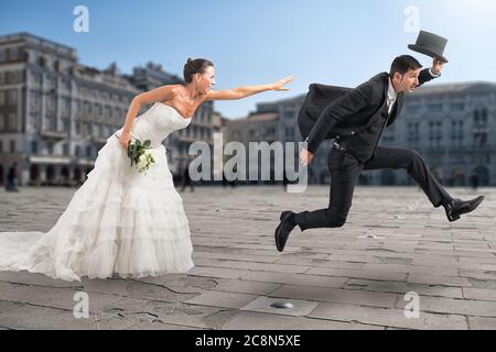 Donna cerca di raggiungere il suo uomo che vuole fuggire velocemente dal matrimonio Foto Stock