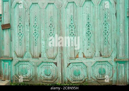 Porte larghe in legno in vecchie case russe. Ornamenti figurativi realizzati in legno. Colori luminosi. Antiche case in legno russo. Foto Stock