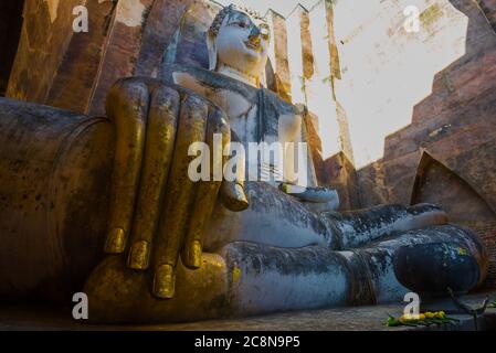 Alla statua gigante di un Buddha seduto (Phra Achana). Le rovine dell'antico tempio buddista Wat si Chum. Sukhothai, Tailandia