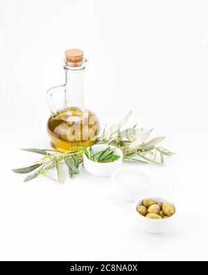 Bottiglia di vetro di olio vergine d'oliva premium, rosmarino e alcune olive con ramificazione di olivo isolata su sfondo bianco. Foto Stock