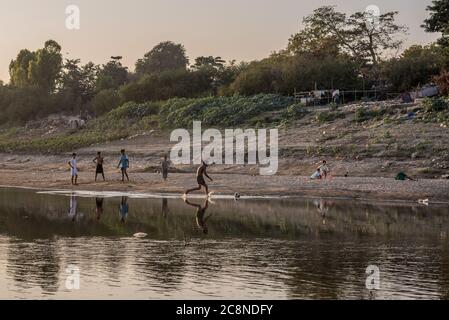 Ragazzi birmani che giocano a calcio sul fiume Irrawaddy a Pakokku, Myanmar Foto Stock