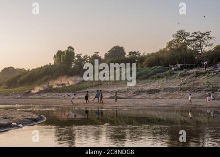 Ragazzi birmani che giocano a calcio sul fiume Irrawaddy a Pakokku, Myanmar Foto Stock