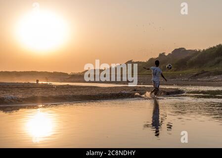 Ragazzi birmani che giocano a calcio sul fiume Irrawaddy a Pakokku, Myanmar Foto Stock