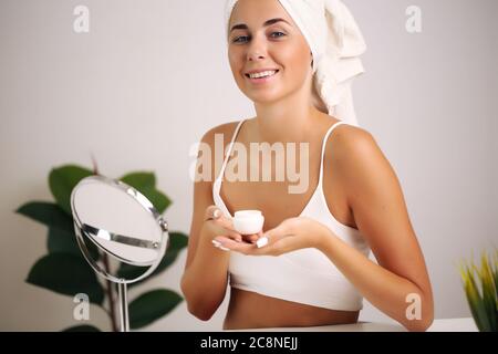 Giovane donna in un accappatoio, porta la bellezza nel bagno Foto Stock