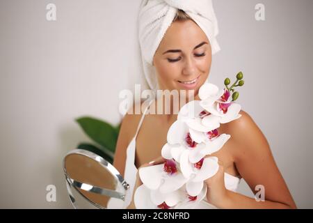 Giovane donna in un accappatoio, porta la bellezza nel bagno Foto Stock