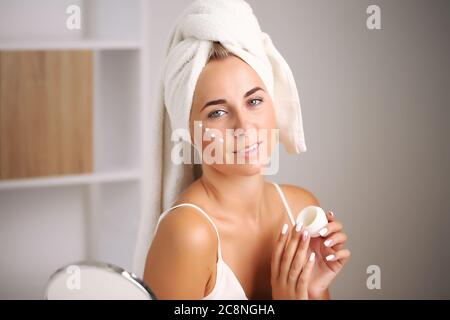 Giovane donna in un accappatoio, porta la bellezza nel bagno Foto Stock