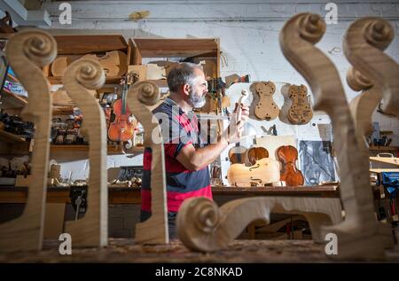 Il luthier Steve Burnet, nel suo workshop a Haymarket, Edimburgo, mette i ritocchi di un violino unico su cui sta lavorando durante il periodo di chiusura in omaggio allo scrittore Robert Louis Stevenson e per celebrare il 170° anniversario dalla nascita del famoso autore nato a Edimburgo. Foto Stock