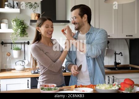 Felice giovane coppia divertirsi cucinare insieme a casa Foto Stock
