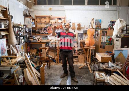 Il luthier Steve Burnet, nel suo workshop a Haymarket, Edimburgo, mette i ritocchi di un violino unico su cui sta lavorando durante il periodo di chiusura in omaggio allo scrittore Robert Louis Stevenson e per celebrare il 170° anniversario dalla nascita del famoso autore nato a Edimburgo. Foto Stock