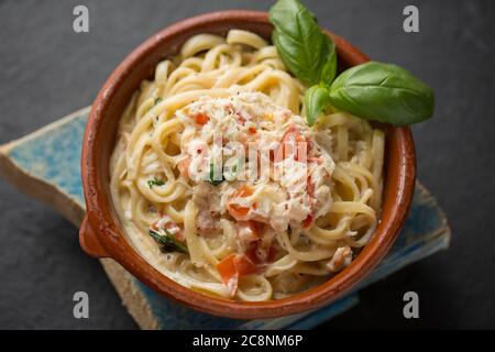Una ciotola di linguine di granchio fatta con la carne bianca da un granchio marrone, Cancer pagurus, che comprende crema, aglio, basilico, peperoncino, olio d'oliva e nero Foto Stock