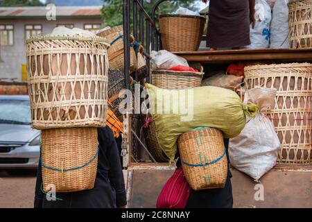 Le lavoratrici trasportano i prodotti locali al mercato comunitario, Maing Thauk, Myanmar. Le donne locali trasportano i cestini di vimini dai metodi tradizionali Foto Stock