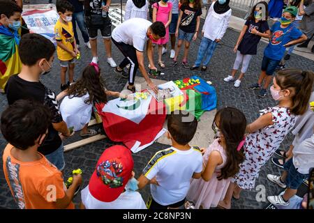 Barcellona, Spagna. 25 luglio 2020. I bambini sostenitori del movimento popolare Rif (Hirak) indossando maschere sono visti mettendo fiori sulla bara simulata coperta con le bandiere del popolo Amazigh e la Repubblica Rif durante il rally.sympatizers del movimento popolare Rif (Hirak) residente in Catalogna riuniti in Plaza Sant Jaume a Barcellona Commemorare la proclamazione della prima repubblica del Rif e ricordare i loro prigionieri politici. Credit: SOPA Images Limited/Alamy Live News Foto Stock