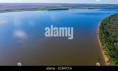 Una chiatta o nave di carico asciutta va a monte del fiume Volga vicino Astrakhan. Fotografia aerea. Foto di alta qualità Foto Stock