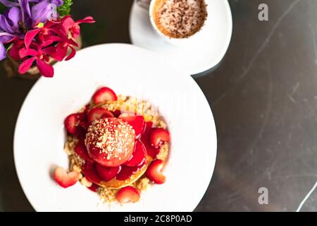 Fresco frittelle fatte in casa Strawberry Crumble su bianco piatto da dessert Foto Stock