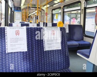 Cartelli sui posti a sedere su un tram di Sheffield che consigliano ai clienti di non sedersi sui sedili per aderire alla distanza sociale per cercare di combattere Coronavirus Covid-19 Foto Stock