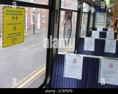 Firma sulla finestra del tram vuoto Sheffield che consiglia metodi di distanza sociale per combattere la diffusione di Covid-19 Coronavirus; segni sui sedili che dicono di non sedersi Foto Stock