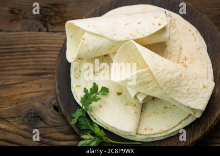 Tortilla di farina integrale sullo sfondo del tavolo di legno Foto Stock