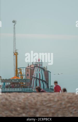 Il molo di Brighton giostra sullo sfondo dietro una famiglia che gioca sulla spiaggia 2020 Foto Stock