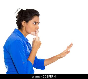 Vista laterale profilo ritratto di una giovane donna che mette un dito sulle labbra con simbolo di shhh, isolato su sfondo bianco. Emozioni negative espulsioni facciali Foto Stock