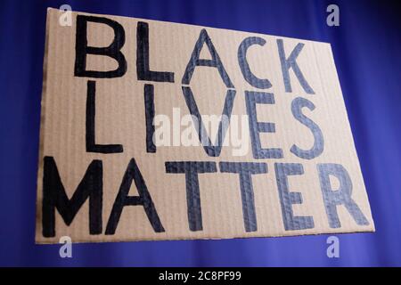 LA VITA NERA È IMPORTANTE su uno sfondo blu sfocato. Nessun concetto di razzismo. Banner di cartone con il testo 'Black Lives Matter'. Concetto della lotta per gli inor Foto Stock