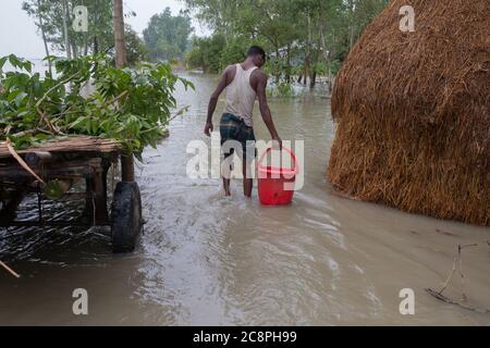 Un agricoltore che fornisce alimenti per i suoi cavalli in un villaggio alluvione trodden Foto Stock