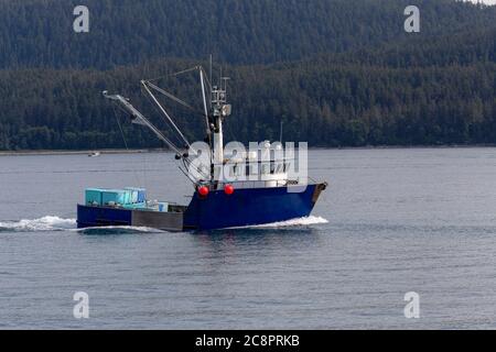 Imbarcazione commerciale da pesca - peschereccio da traino nell'oceano Pacifico con toutains in background. Juneau , Alaska Foto Stock