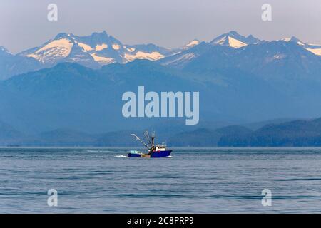 Imbarcazione commerciale da pesca - peschereccio da traino nell'oceano Pacifico con nevi in background. Juneau, Alaska Foto Stock