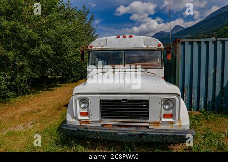 Vecchio autobus della scuola bianca abbandonato a Skaway, Alaska, Stati Uniti Foto Stock