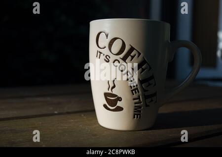 Primo piano di una tazza di caffè illuminata dalla luce del sole al mattino. Contrasto elevato Foto Stock