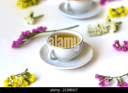 Tè Il tè verde. Il tè alle erbe. Foglia di menta. Tè con sapore di apple. Il tè in un bicchiere di vetro con fiori e foglie di tè essiccato fettine di lime. tè alle erbe e m Foto Stock