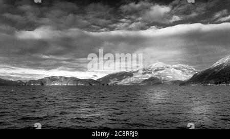 Foto in bianco e nero del paesaggio invernale del lago Harrison e delle montagne circostanti alle sorgenti termali di Harrison nella British Columbia, Canada Foto Stock